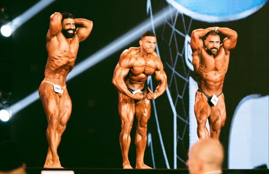 Coach posing on stage next to other competitors