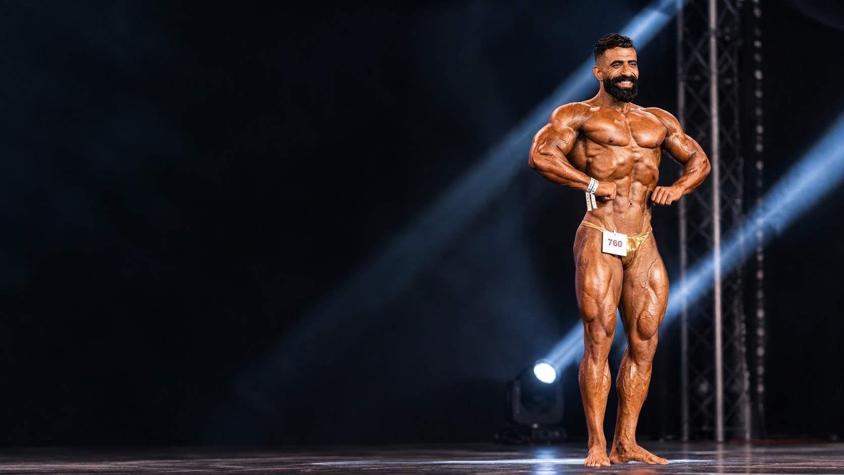 Coach posing on stage under the spotlights
